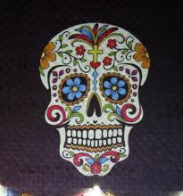 A Dia de muertos skull colorfully decorated, upon a dark background