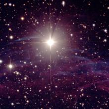 A bright star with pink and blue gas clouds.