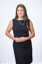 Anoush Baghdassarian stands in a black dress with hands folded.