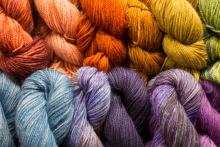 Many colorful skeins of yarn lined up.