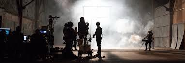 Silhouette of band playing in a large space with fog in the background