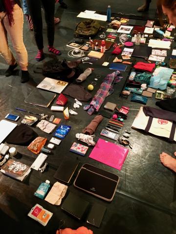 Photo of miscellaneous items (clothes, books, keys, phones, etc.) laid out on the floor