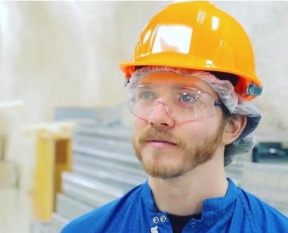 Image of person wearing safety goggles and a safety hat