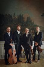 Members of the quartet standing next to each other, holding their instruments