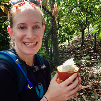 Emma Ross MAIEP OCRM '18 Center for the Blue Economy Summer Fellow, she is smiling, holding a frozen delight in the jungles of Belize