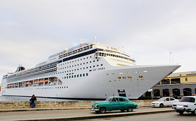 Cruise ship and old car, likely in Cuba