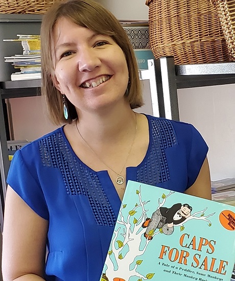 Kirstin van Gend smiling and holding a book 