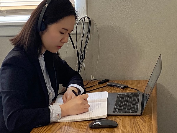 Student with headset on computer working on interpretation assignment