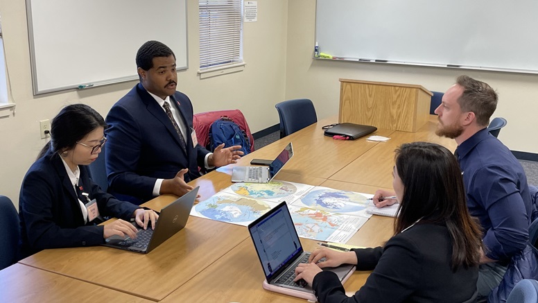 Global security students engage in a negotiation session representing China and Norway as part of the International Strategic Crisis Negotiation Exercise. 