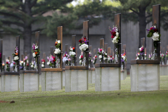 an image of a memorial with chairs covered in flowers in rows