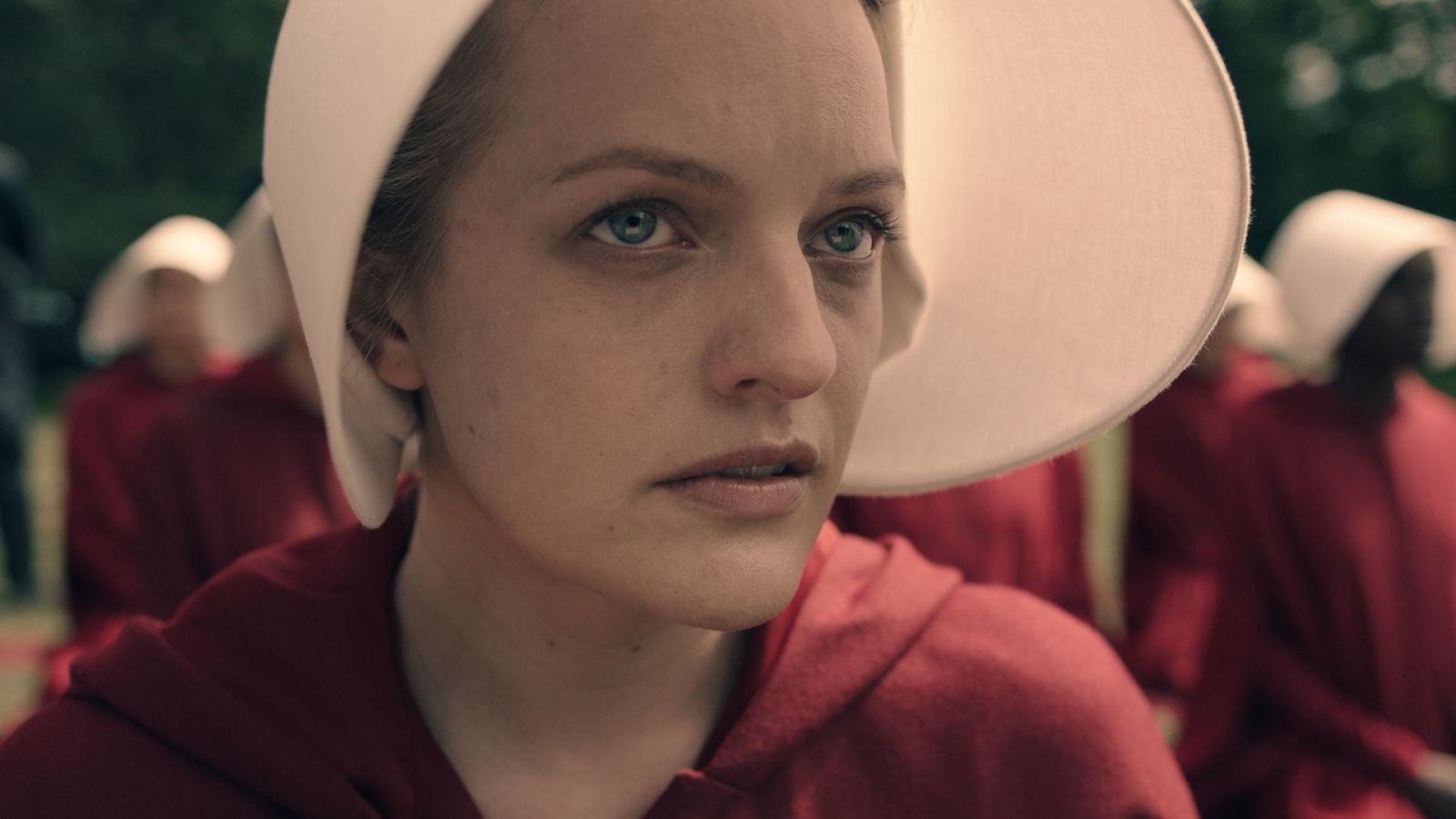 A woman in a red outfit and white hat stares up