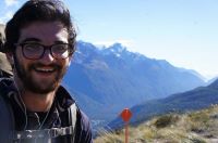Miles with a wide smile looking amazed at the wonder of nature he is standing in--mountains behind