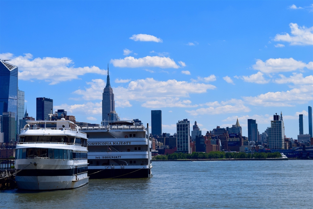 Manhattan with Cruise Ship, blue sky, blue water, two large cruise ships sit against city skyline