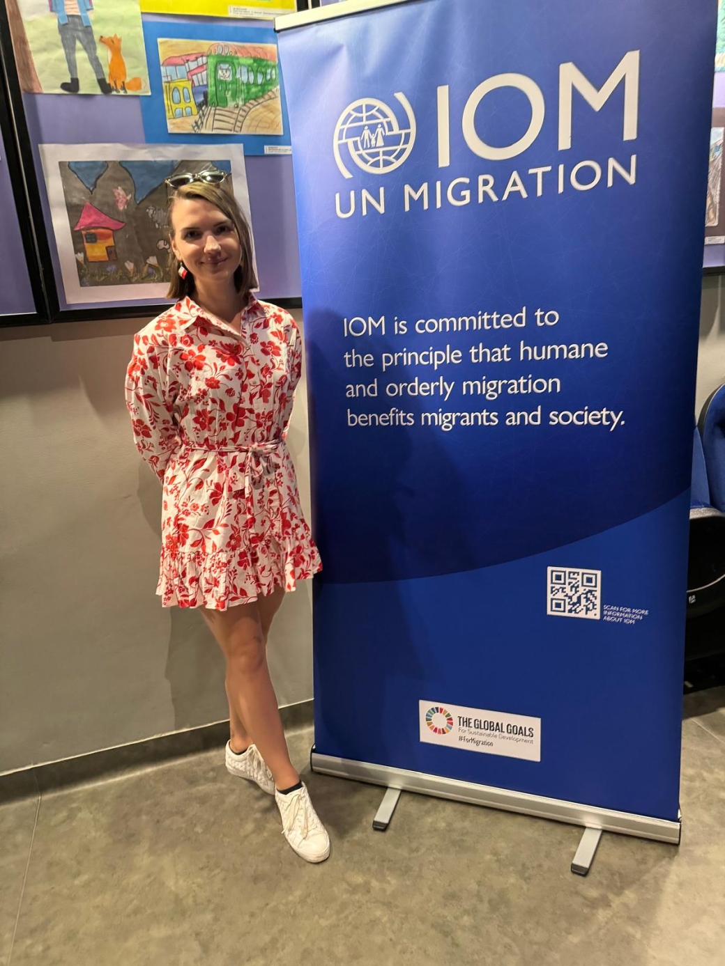 Ola in front of the IOM Migration banner in Poland
