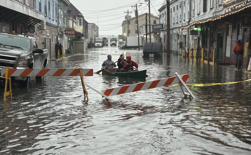 Paddlers navigate the flooded Custom House Wharf in Portland, ME 