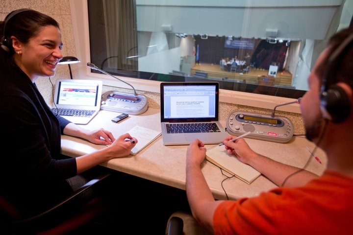 Two students interpreting an event in the Irvine Auditorium at the Middlebury Institute