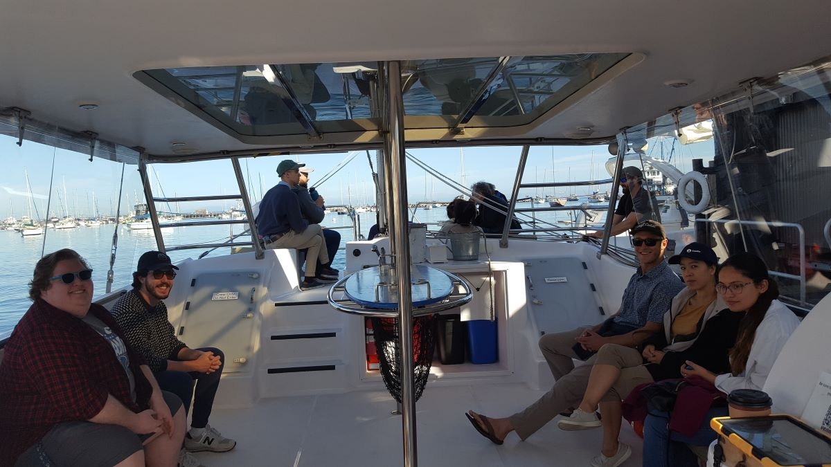 people on a catamaran sailing boat, about to set sail for two hours, looking happy, smiling