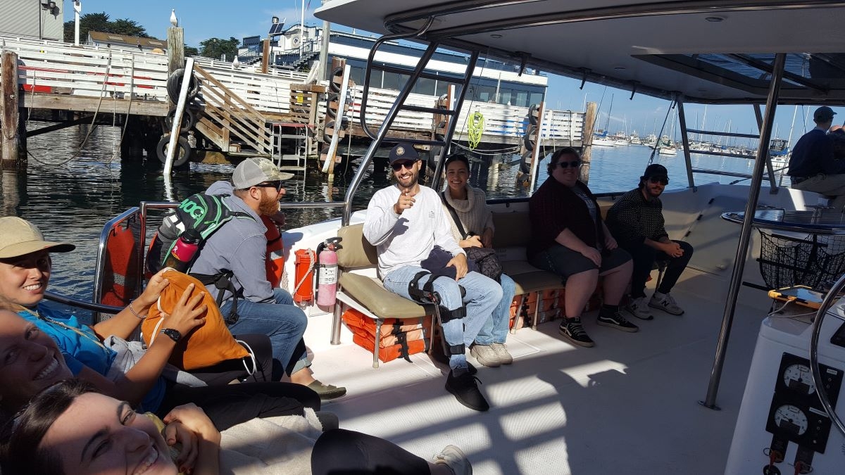 people on a catamaran sailing boat, about to set sail for two hours, looking happy, smiling