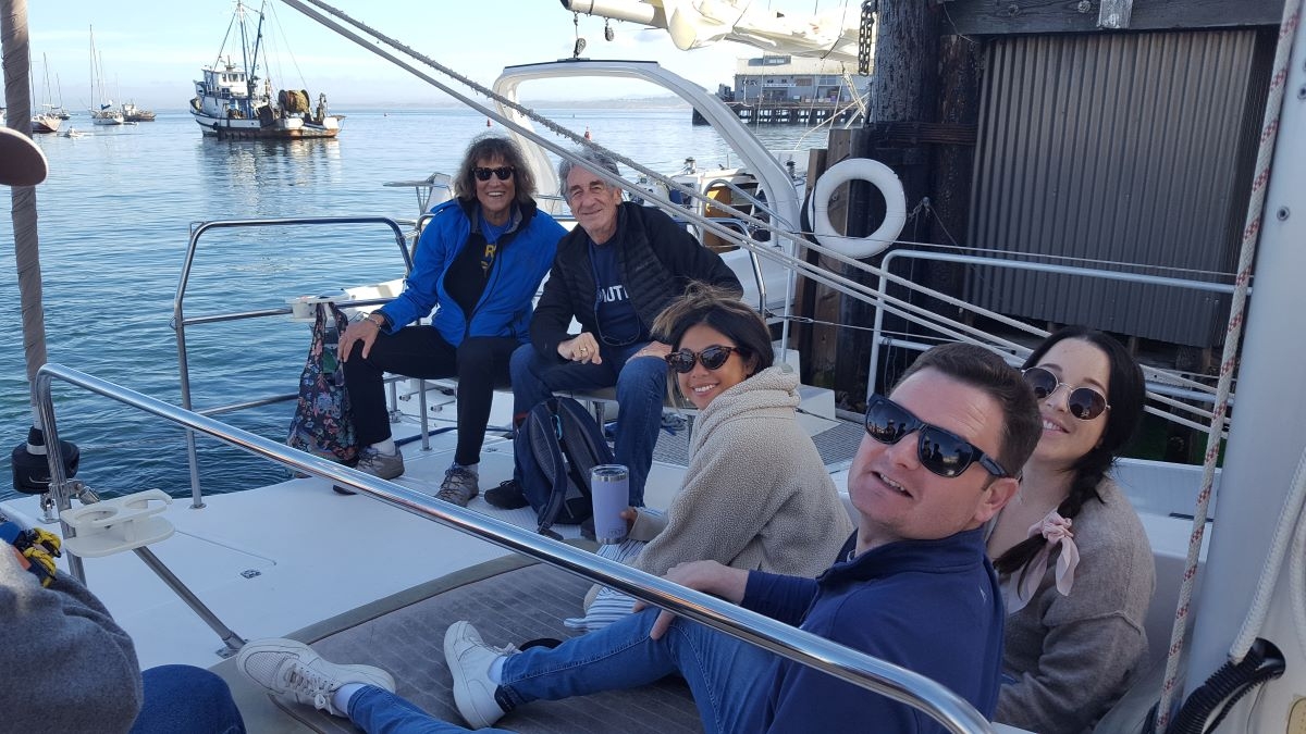 people on a catamaran sailing boat, about to set sail for two hours, looking happy, smiling