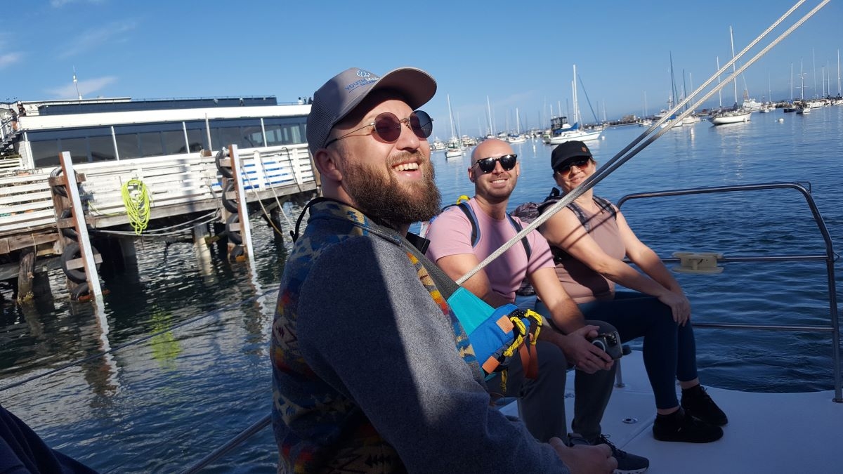 people on a catamaran sailing boat, about to set sail for two hours, looking happy, smiling