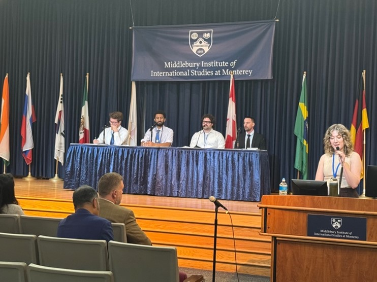 A panel of 4 people on stage