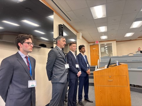 4 people standing in front of a podium