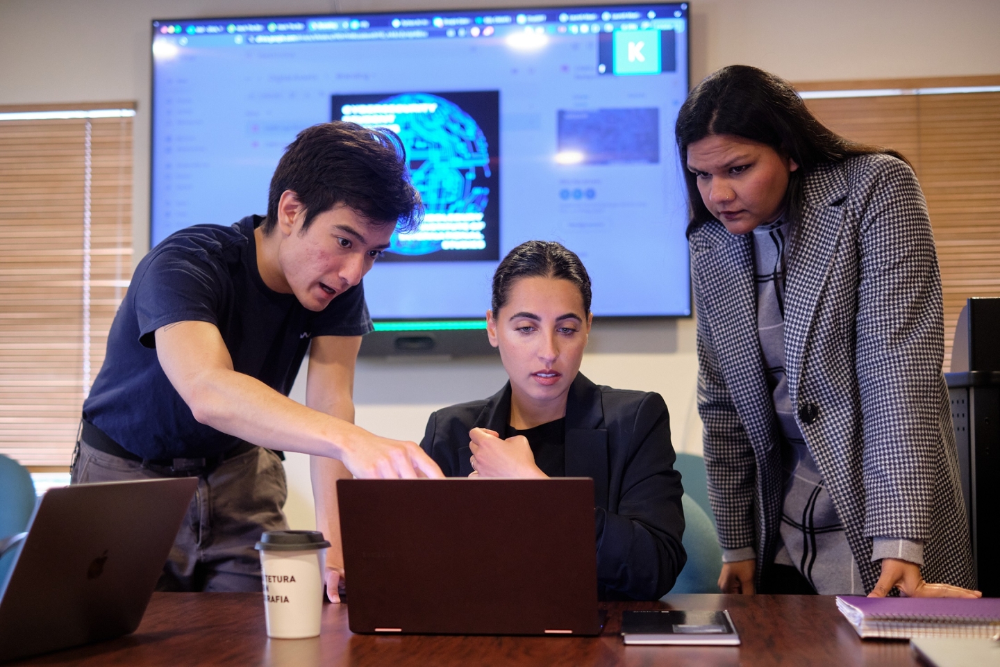 Three students looking at a computer