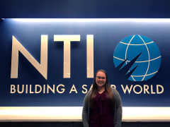 Sara Beth Marchert standing beside the Nuclear Threat Initiative sign