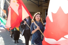 Students walking with flags for winter commencement 