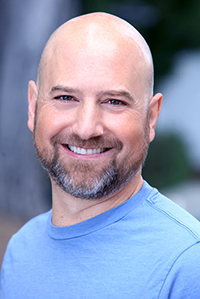 Jason Scorse, Director of the Center for the Blue Economy, young yet bald white dude wearing blue t-shirt