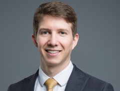 Profile image of Bryan Herbert in a suit and tie, smiling at the camera