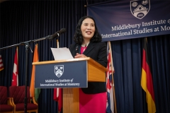 A speaker addresses an audience from a lectern.