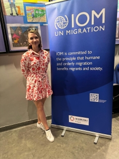 Ola in front of the IOM Migration banner in Poland
