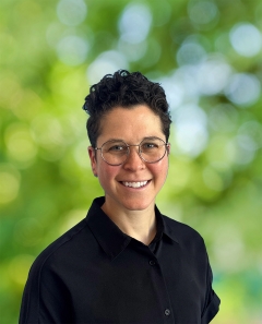 Clesi Bennett smiling brightly with a black shirt and short black hair