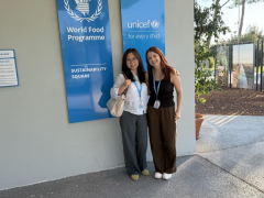 Youlin Xie and Sierra Lennon standing beside World Food Programme and UNICEF signs in Rome