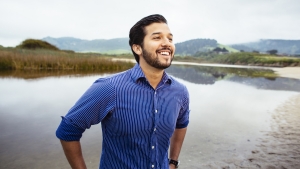 Student, William Franco, smiling as he stands by a marsh in the Monterey area