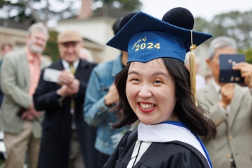 Graduate smiling at 2024 spring commencement