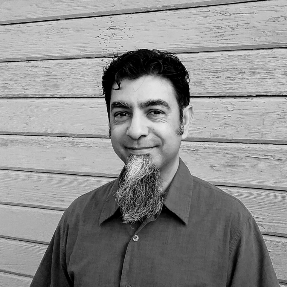Headshot of Minal Mistry, dark haired man with righteous goatee