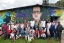 a group of students posing in front of a mural in rural Colombia