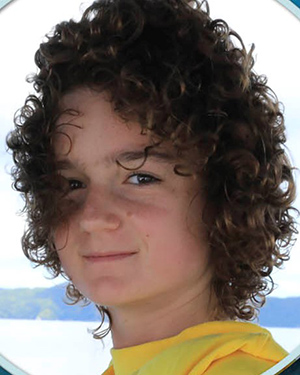 Charley Peebler, Co-Founder, Heirs To Our Oceans--Girl of 16 with curly, short hair, yellow t-shirt, looking determined directly at camera