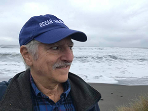 David Helvarg, Director of Blue Frontier, older white dude with blue cap on, shown in front of ocean in Humbolt, CA