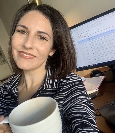 Amelia Evrigenis, translation and localization management alumna, enjoying a cup of coffee at work