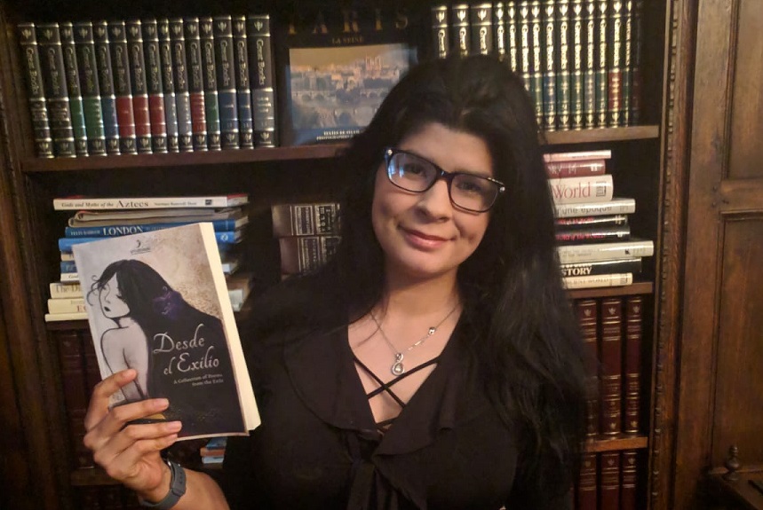 Marianna Guedez holding a copy of her book Desde el Exilio