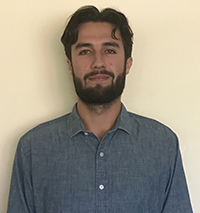 Ben Dorfman looking smart with short dark hair, mustache and beard in a grey-blue collared shirt