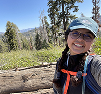 Marissa Castro, smiling on a sunny day in a mountain meadow