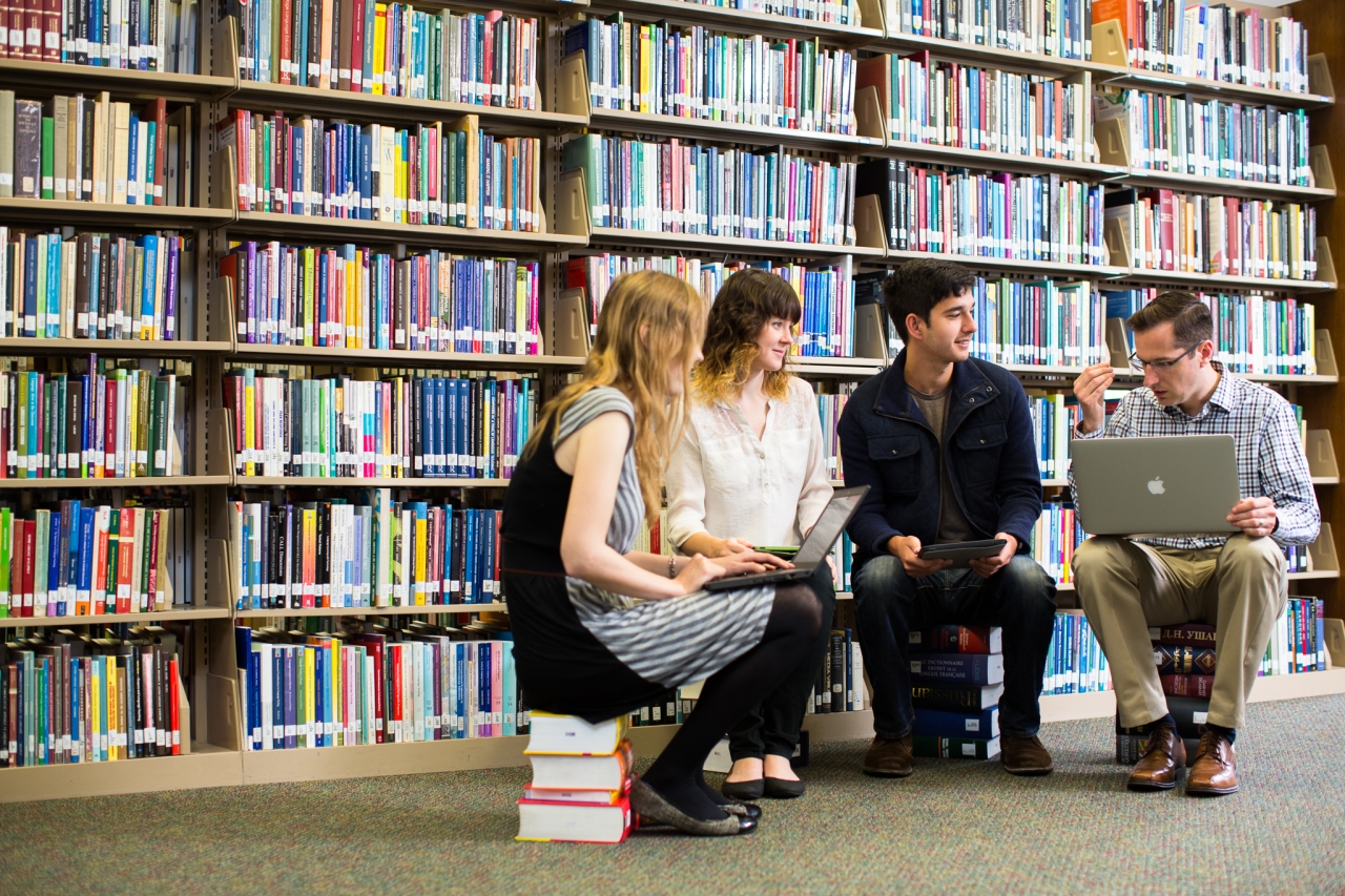 Max Troyer Sitting on Books with Students