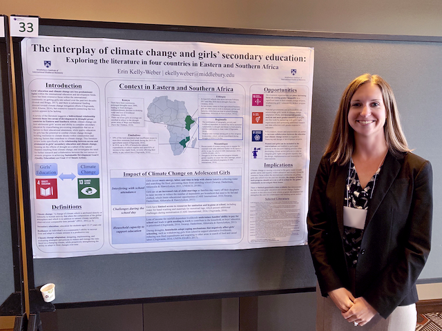 Erin Kelly Weber standing on front of her poster