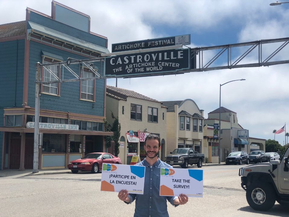 Adam Schreier holding signs for surveys in Castroville