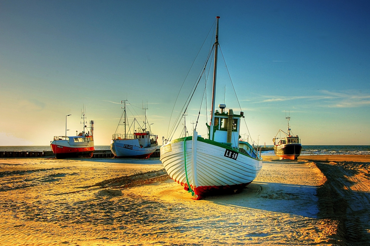 Fishing Boats on land with sky and sea behind