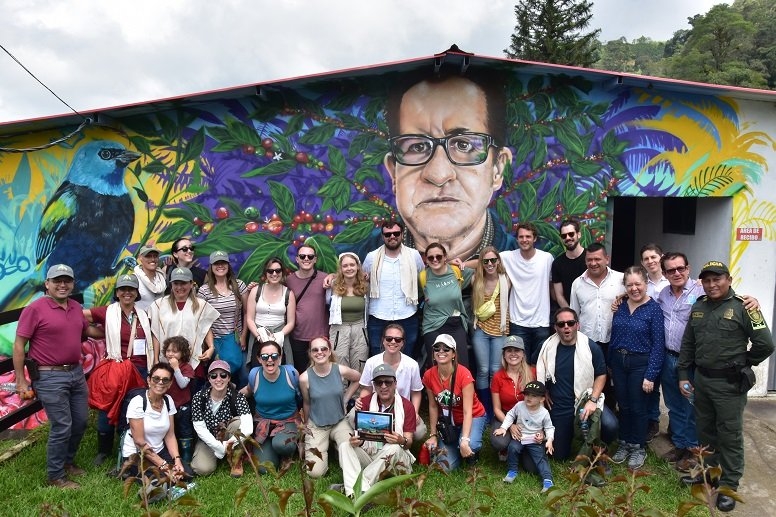 a group of students posing in front of a mural in rural Colombia